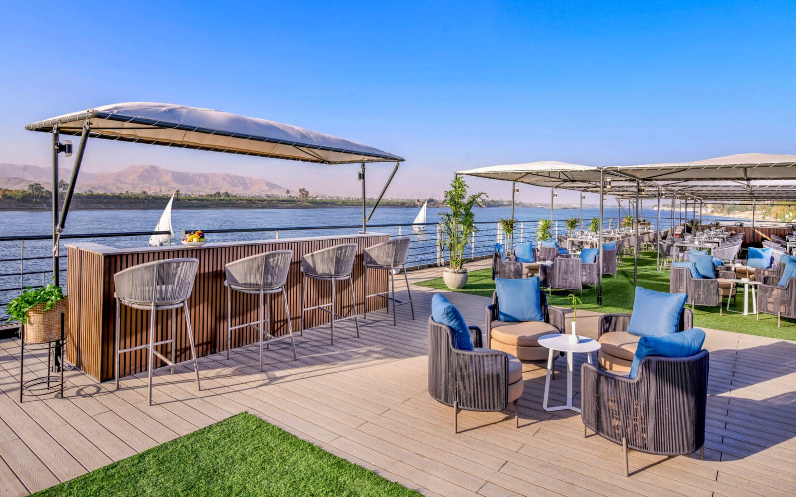 The expansive sundeck of the Historia Nile Cruise, featuring a swimming pool, cabanas, and unobstructed 360-degree views of the Nile River.
