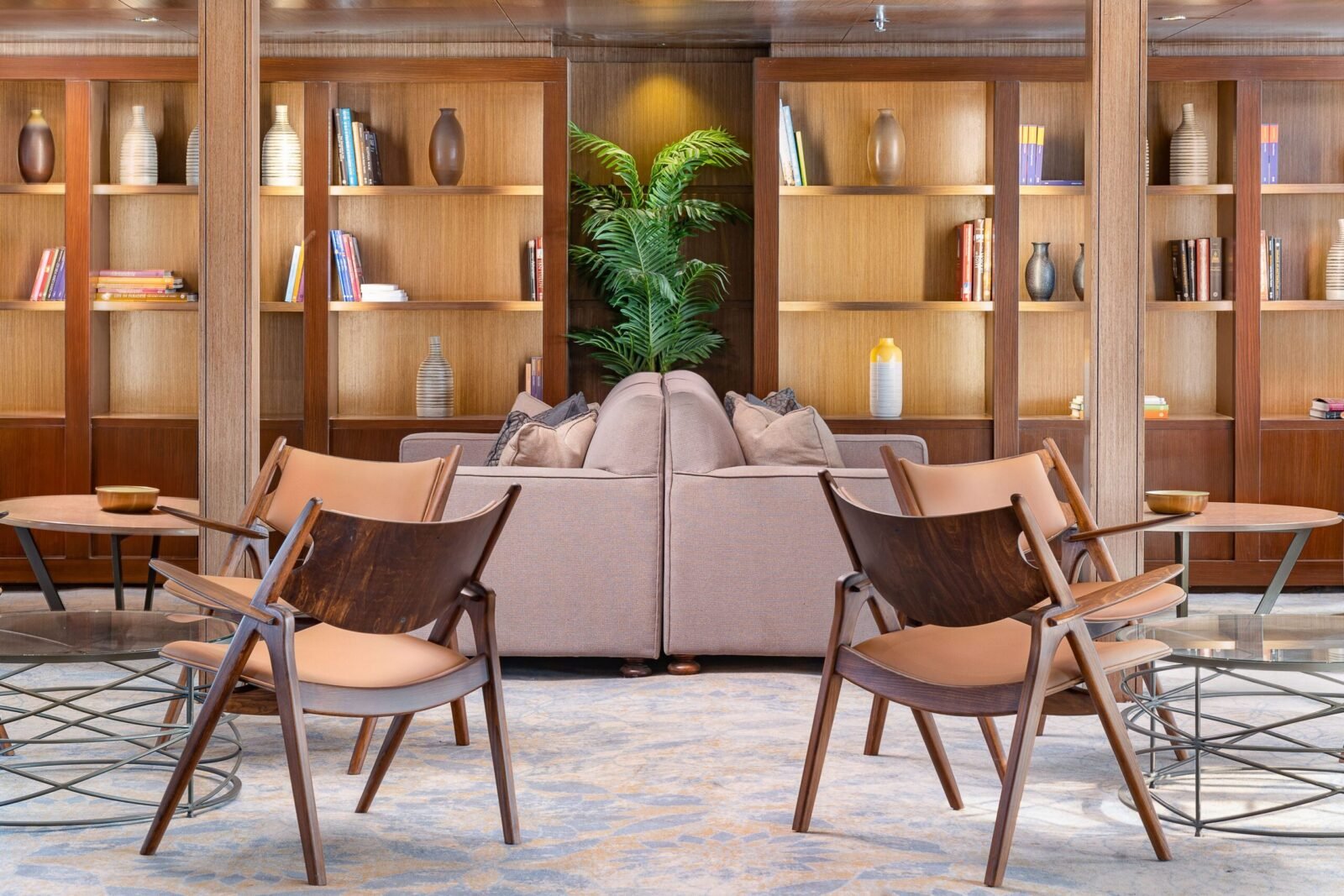 Cozy library aboard the Jaz Viceroy Nile Cruise featuring comfortable armchairs, a selection of books, and a large window providing an excellent view of the Nile River.