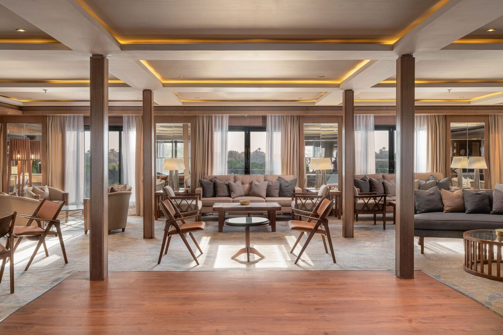 Elegant and brightly lit Jaz Viceroy Nile Cruise lounge bar, featuring comfortable seating, a fully stocked bar counter, and large windows