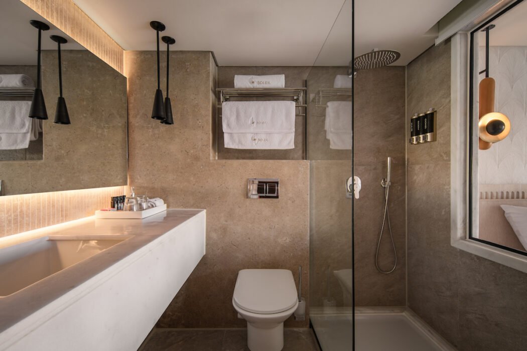 A clean and modern private bathroom in a cabin aboard the MS Le Soleil Nile cruise, featuring a glass-door shower and contemporary fixtures.