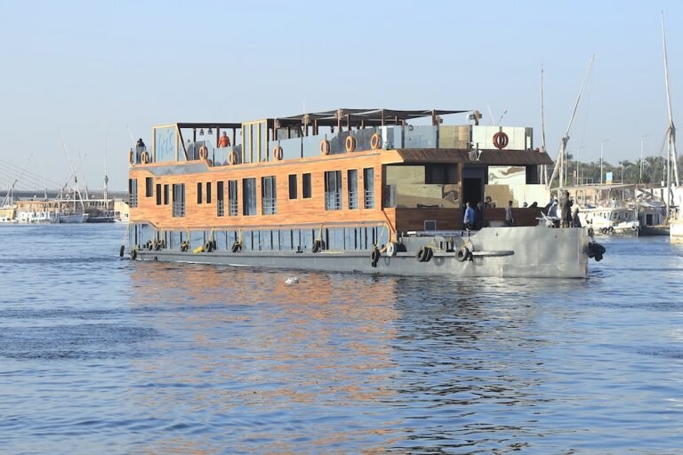 Luxurious shaded sundeck on the Akhnaton Dahabiya with comfortable seating, a Jacuzzi, and panoramic views of the Nile.