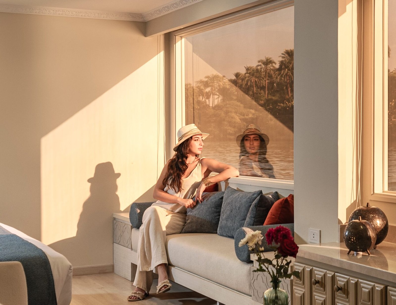 Nawara Luxury Dahabiya guest meditating on the upper deck overlooking the Nile River at sunset.