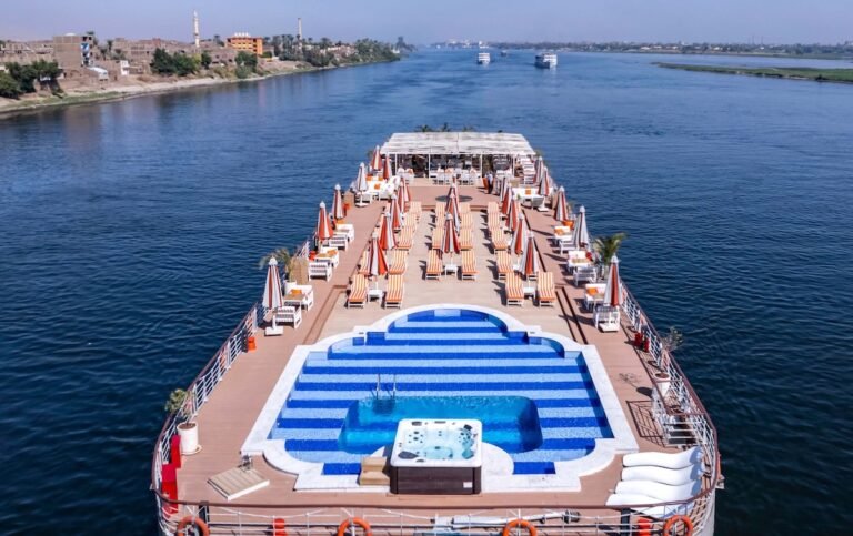 Grand Mandarin River Nile Cruise ship sailing with guests relaxing on the sundeck and swimming pool from Luxor to Aswan