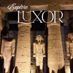 Colossal illuminated statues of King Ramses II standing before the entrance of Luxor Temple at night.