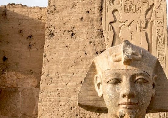 Ancient statues of Pharaoh Ramses II at Abydos Temple, showcasing detailed carvings and hieroglyphics in Upper Egypt