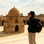 Tourist taking a photo at a historic mosque in Islamic Cairo, Egypt