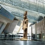 Grand Egyptian Museum entrance with the giant statue of Ramses II and tourists enjoying a guided Egypt tour with Nile Cruisen
